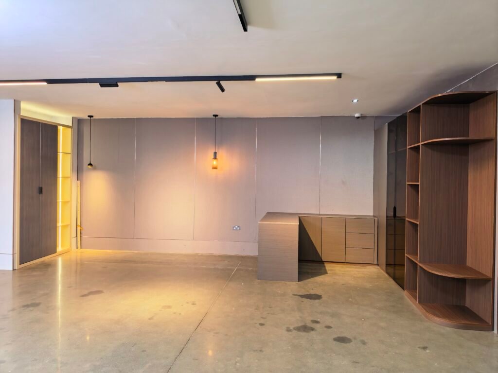 Kitchen cabinet installation with warm wood accent wall in Uganda Doors Interior Kampala showroom