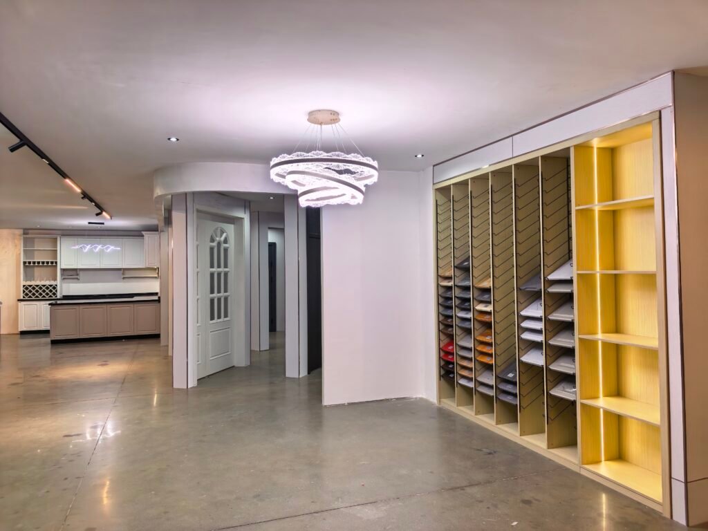 Modern TV wall unit with yellow accent storage shelves displayed in Uganda Doors Interior showroom Kampala